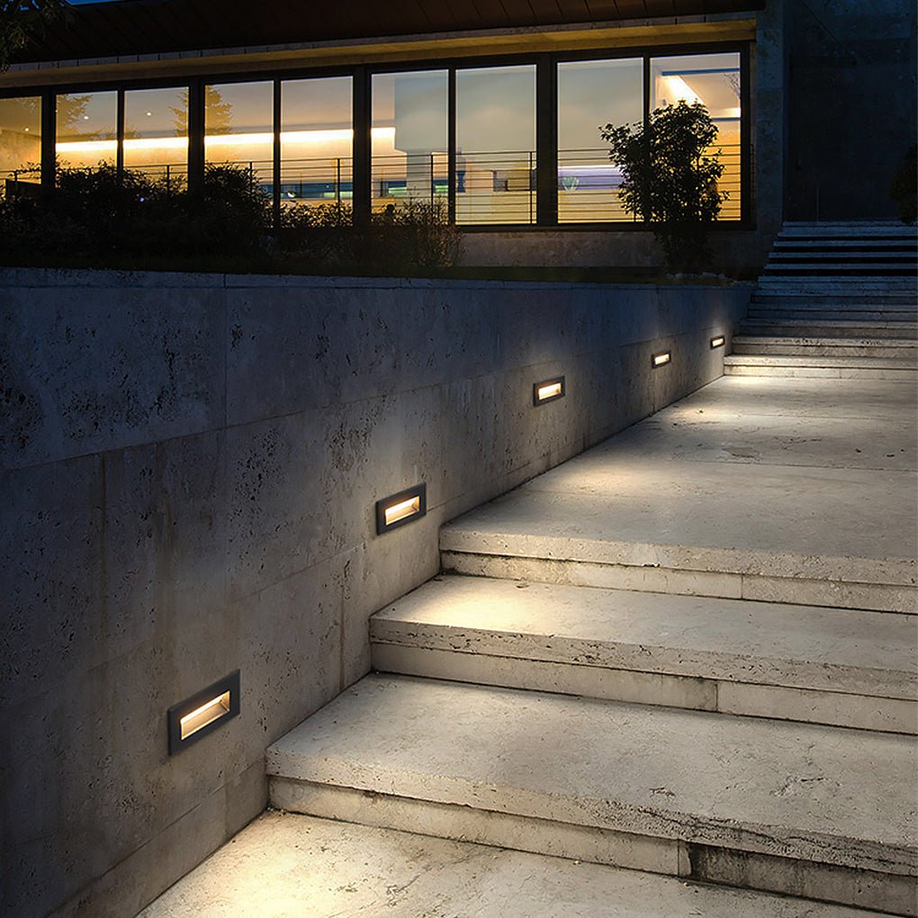 Recessed step lights along an outdoor stair wall at dusk