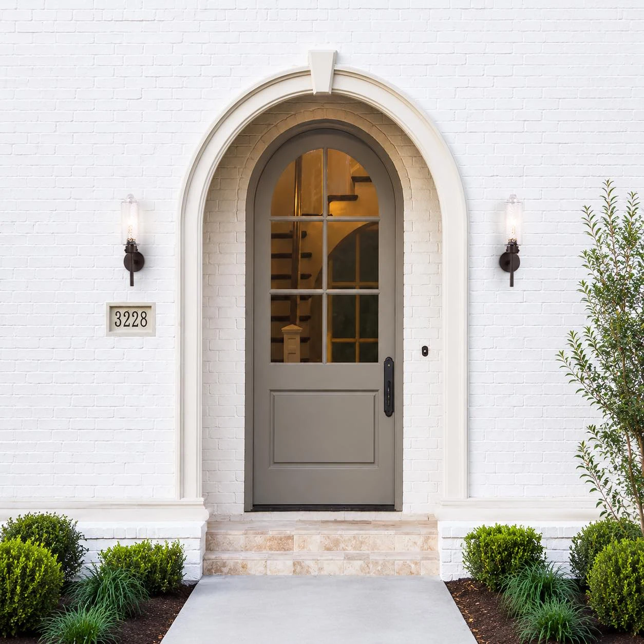 Pair of rippled glass wall sconces beside an exterior entryway