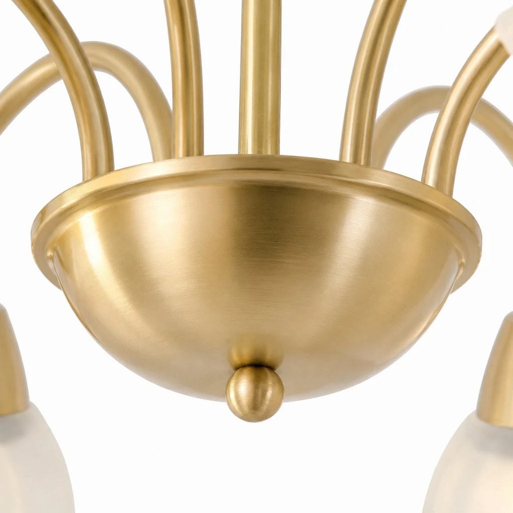 Close-up of the brushed gold central hub and curved chandelier arms