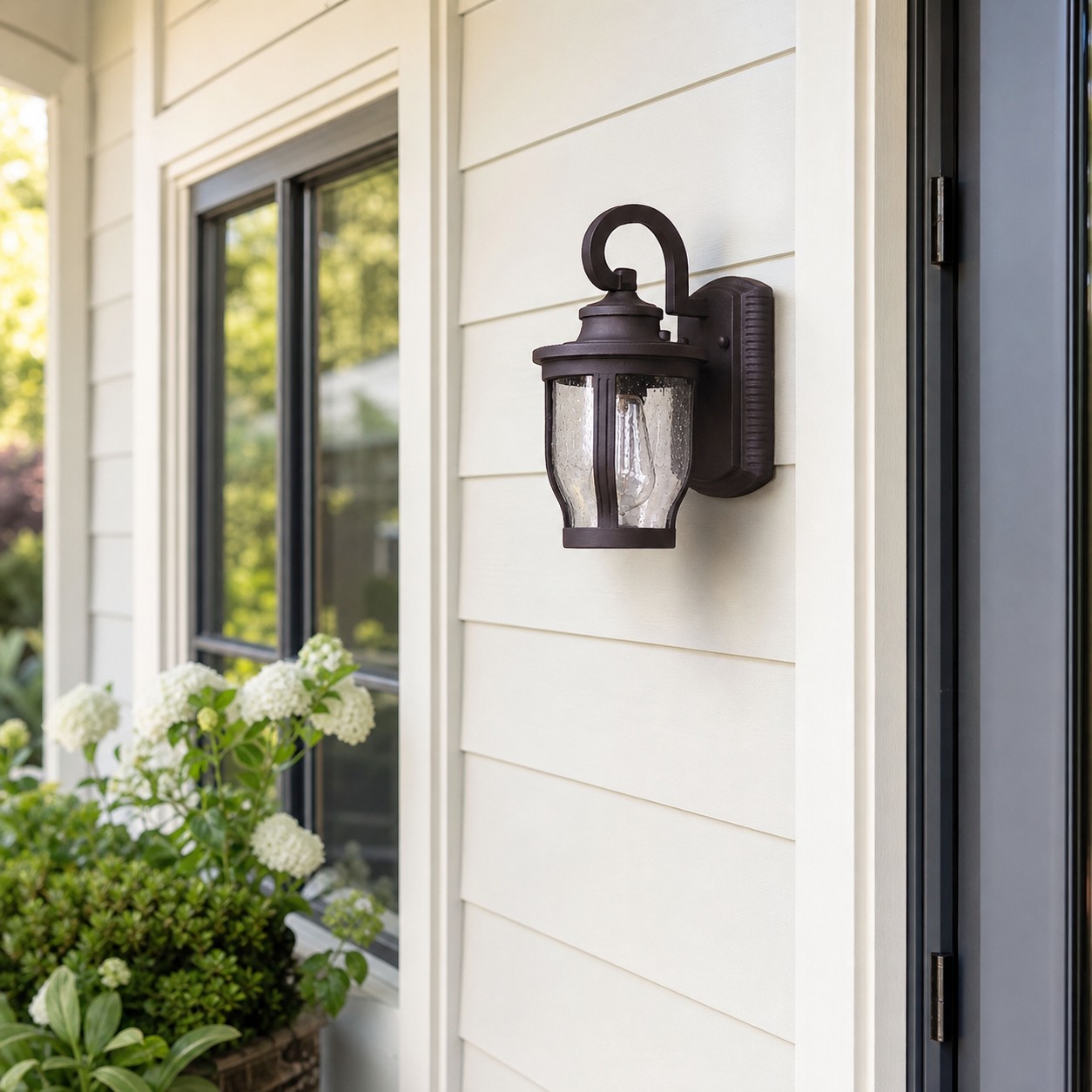 Black rain glass outdoor wall sconce beside a front door