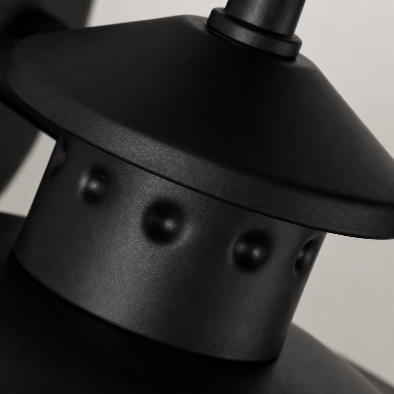 Rounded black cap with raised rivet detail