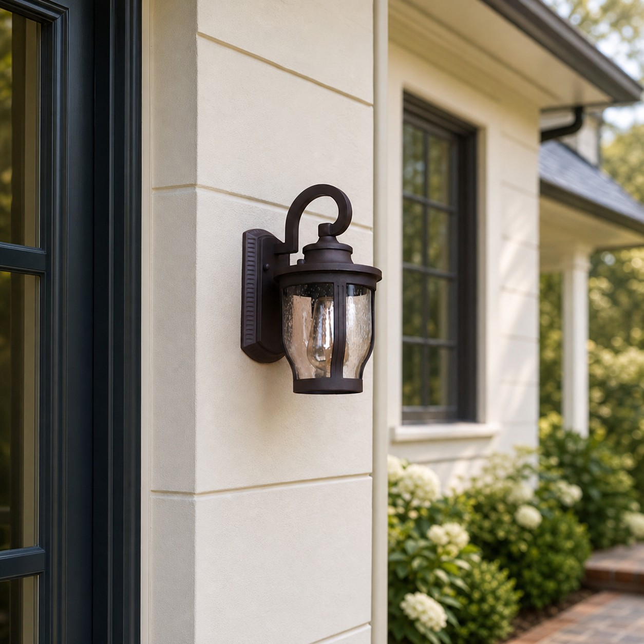 Antique bronze rain glass outdoor wall sconce on an exterior wall