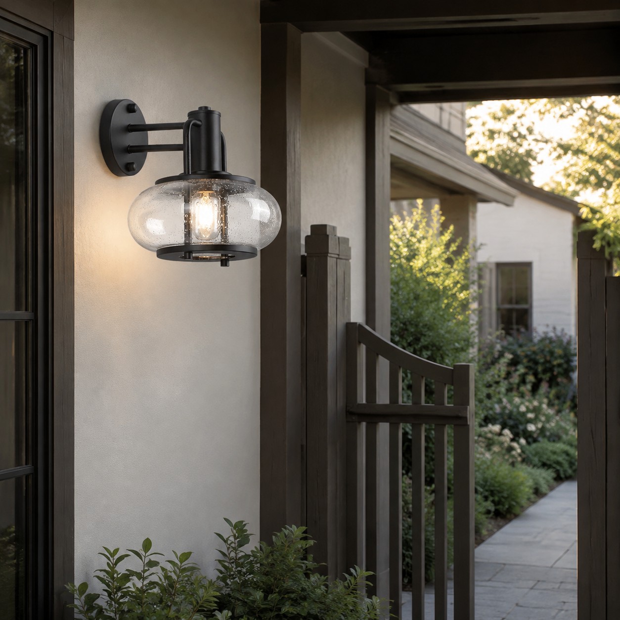 Black bubble glass wall sconce at a covered garden entry