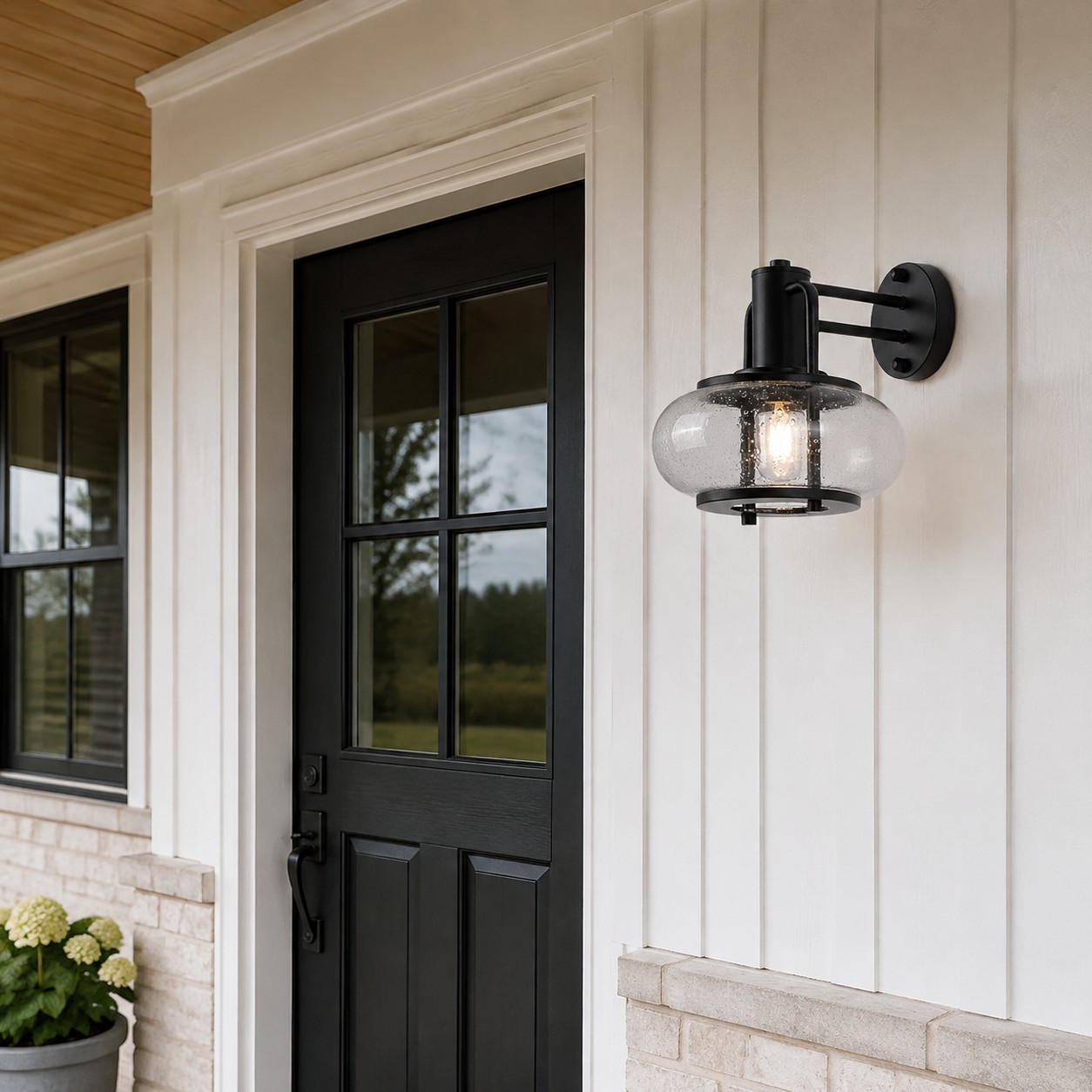 Black bubble glass wall sconce beside a covered front door