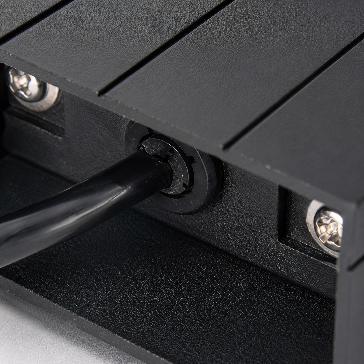 Close-up of rear cable grommet and fixing screws on the recessed housing