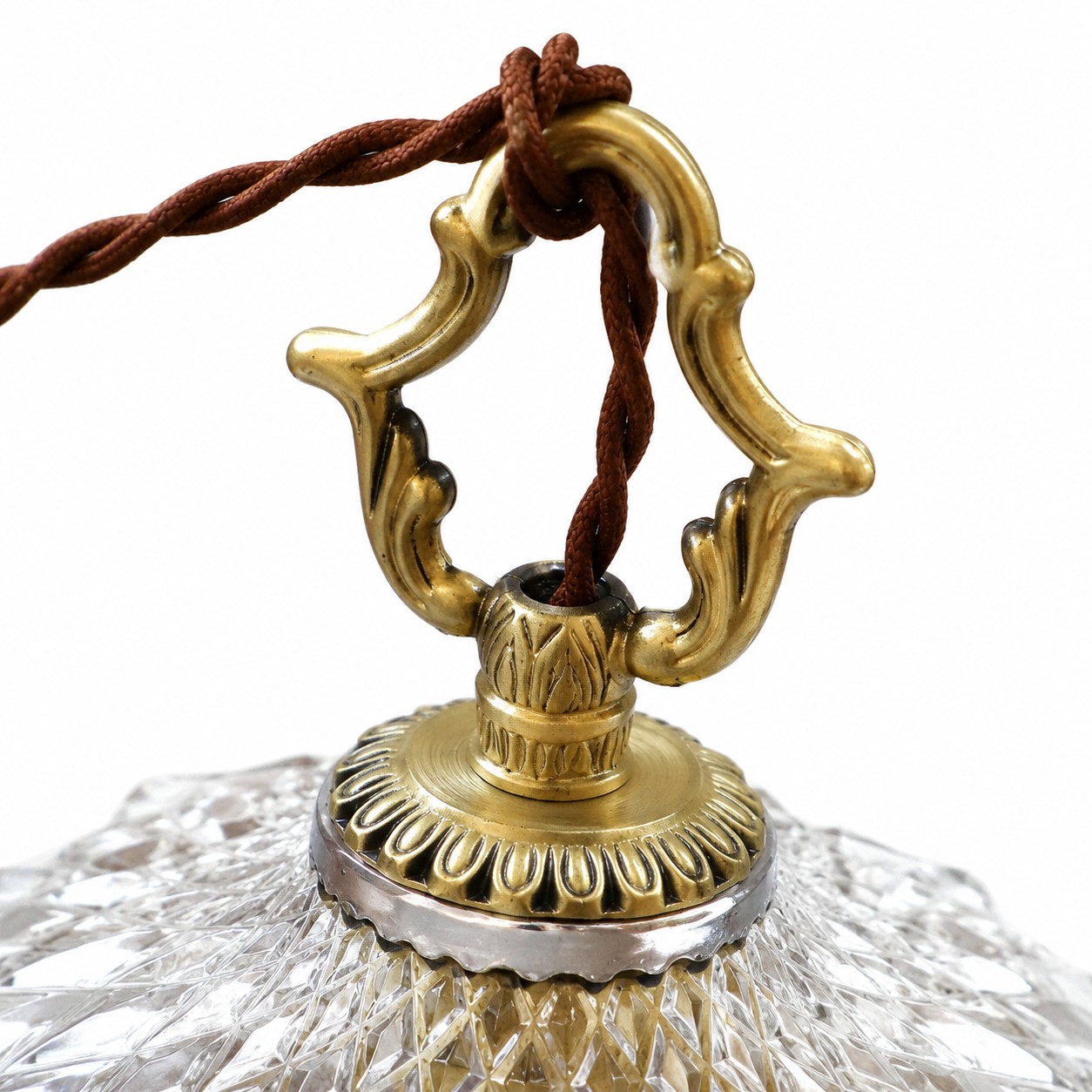 Close-up of the ornate gold cap where the twisted cord meets the glass