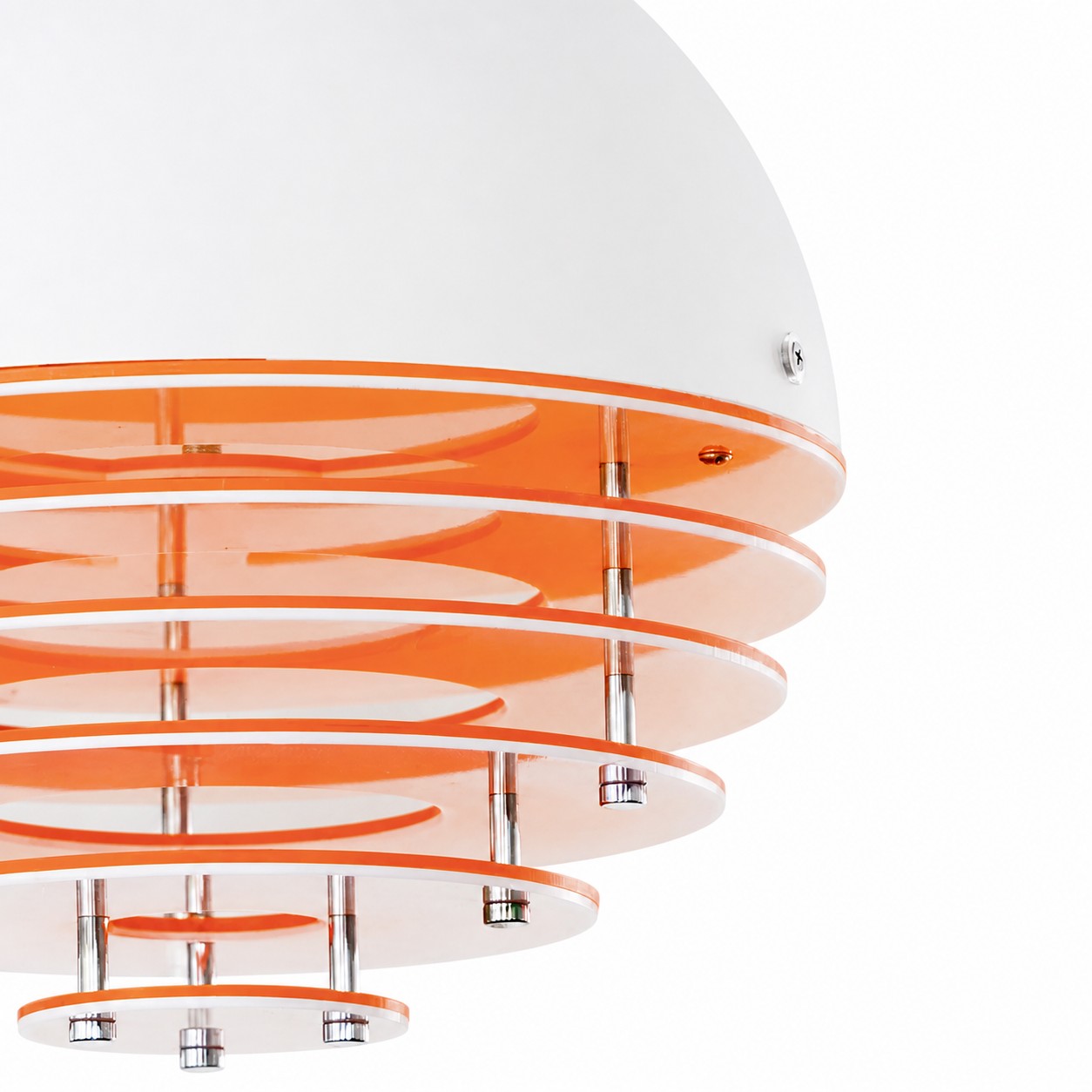Close-up of stacked orange discs and chrome spacers under the white dome