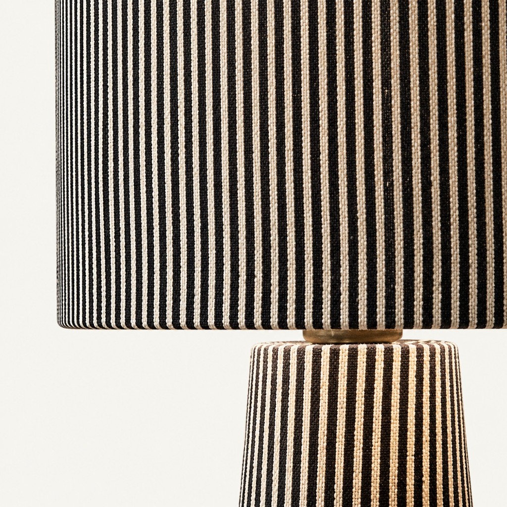 Close-up of gray striped shade meeting the tapered base with a brass collar